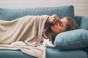 Woman sick on couch with sinus infection